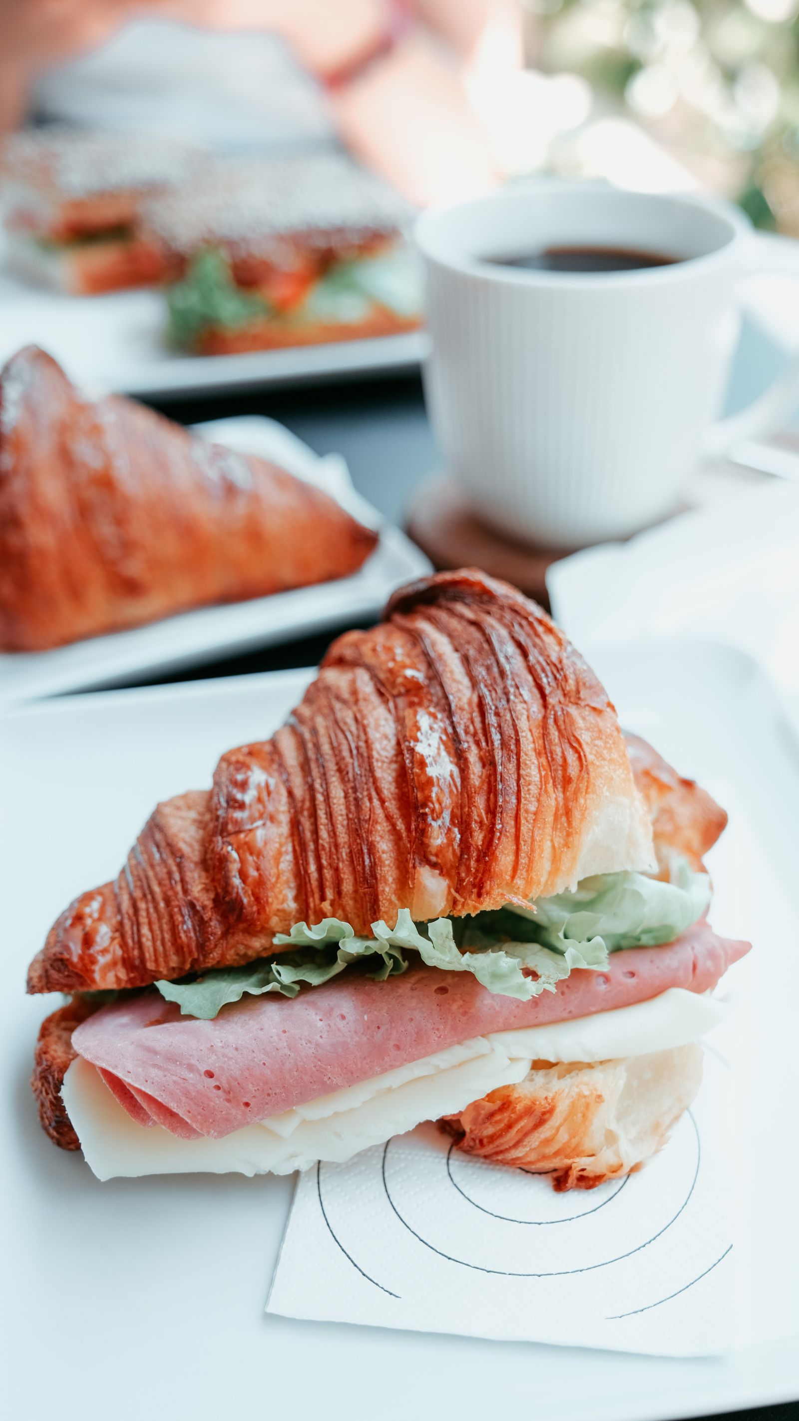 Medialuna de jamón y queso con café